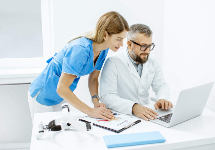 Doctor and nurse reviewing patient information on a laptop together