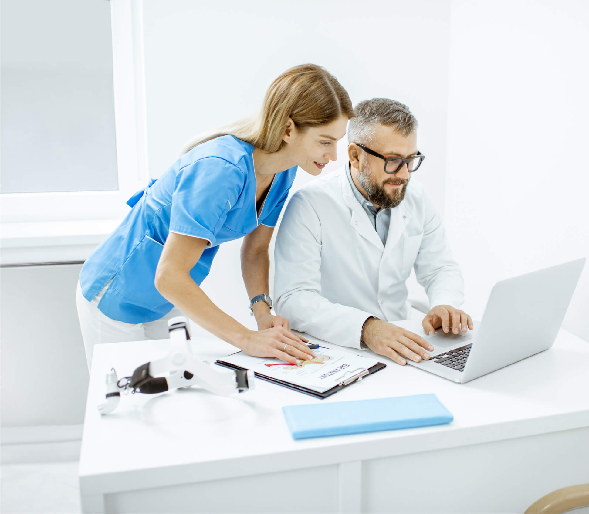 Doctor and nurse reviewing patient information on a laptop together